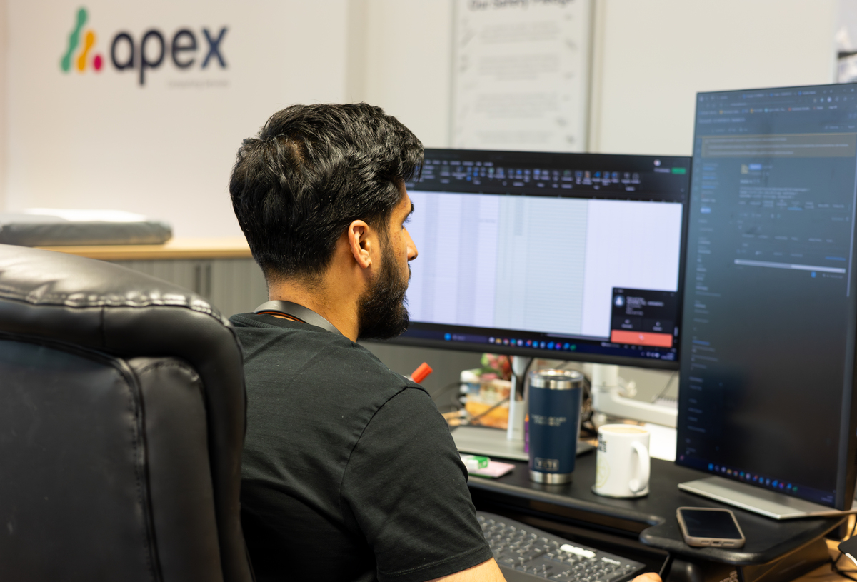 Apex employee facing away from camera looking at his computer. Business continuity manchester IT