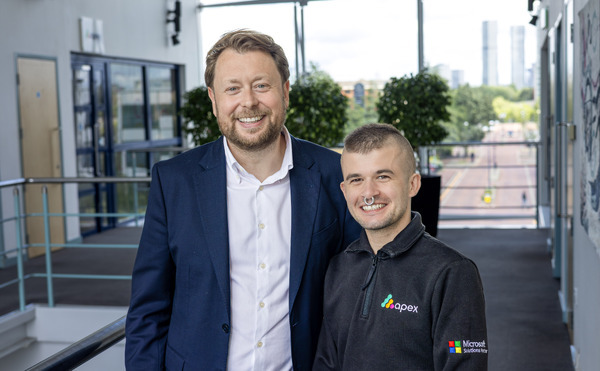 two employees smiling at the camera on a balcony