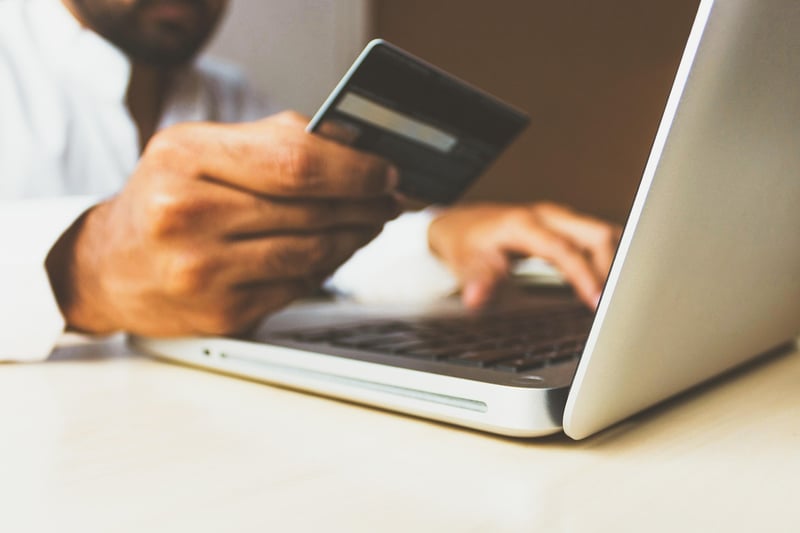 a man making an online payment with a bank card on a website on his laptop